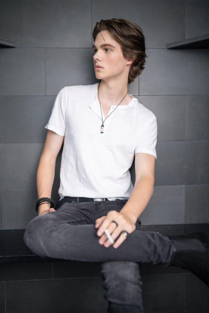 Deric Bucher, seated on gray tile