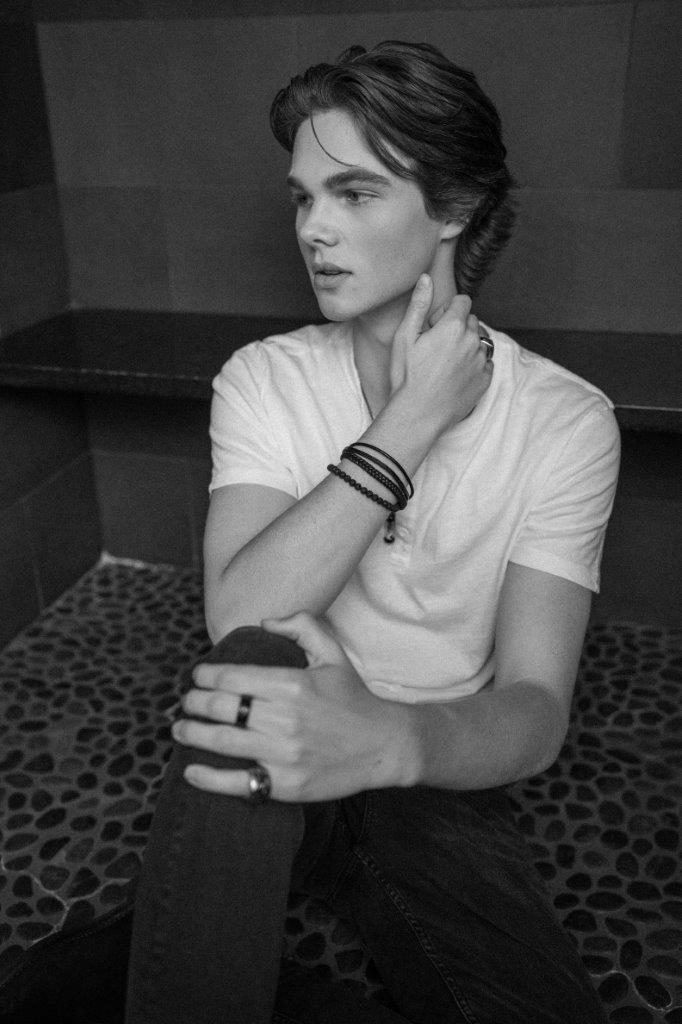 Deric Bucher seated, black and white