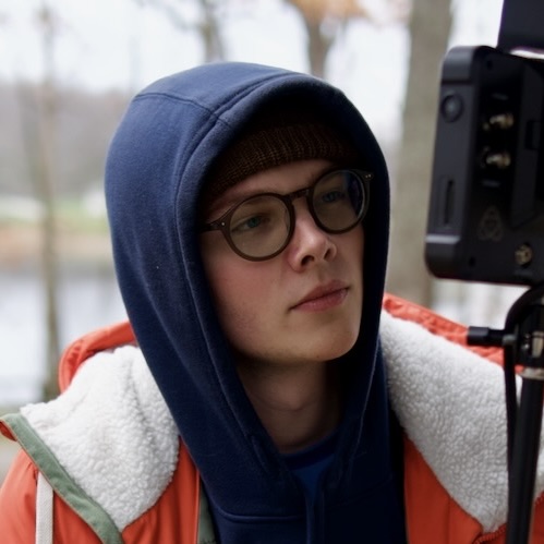 Deric Bucher on set behind a camera monitor